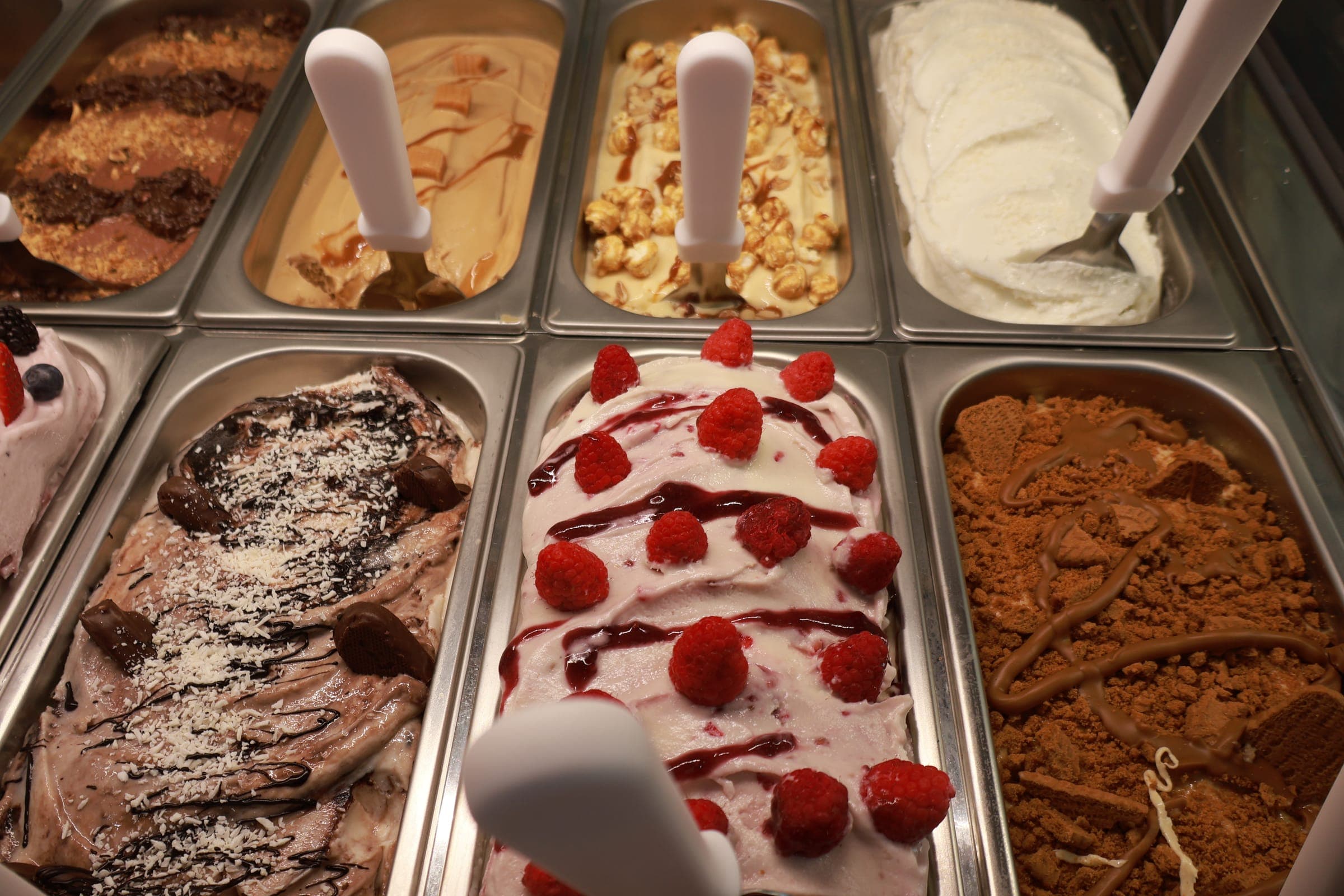 Trays of freshly made gelato, including strawberry, chocolate and cookie flavors