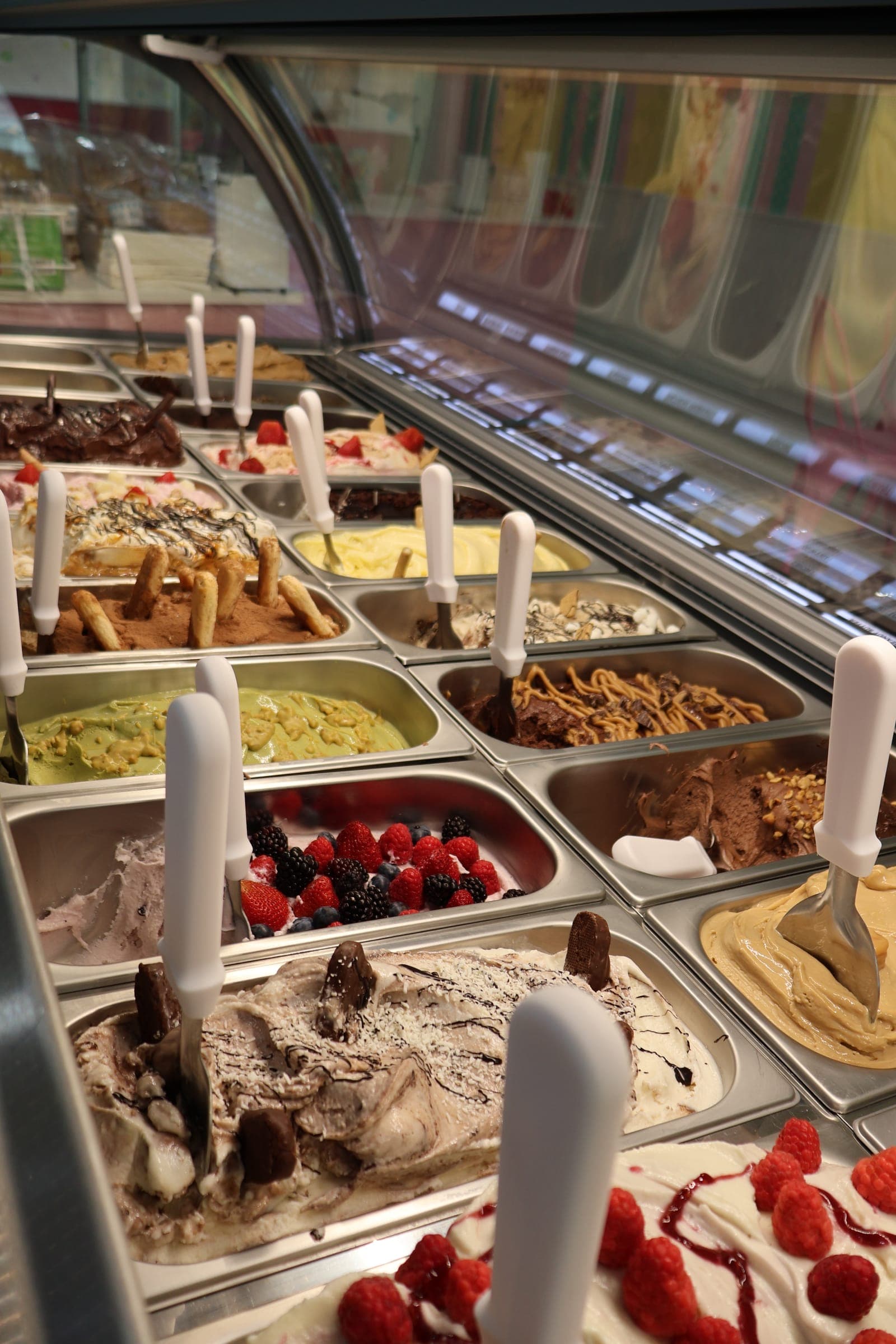 Our gelato case, filled with fresh flavors topped with berries, cookies and chocolate